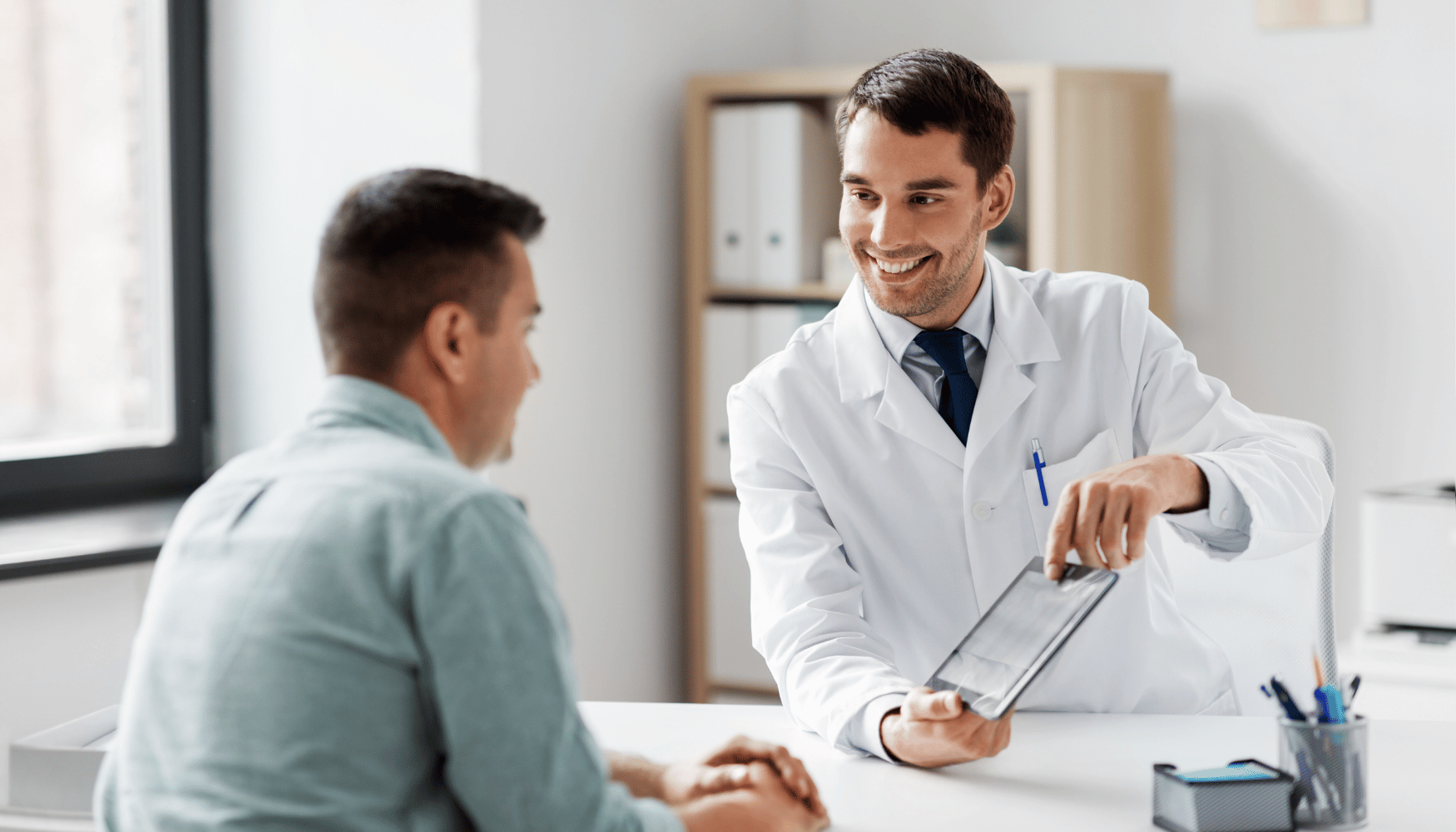 Doctor discussing medical information with a patient, highlighting communication and patient care during consultations or clinical trials.
